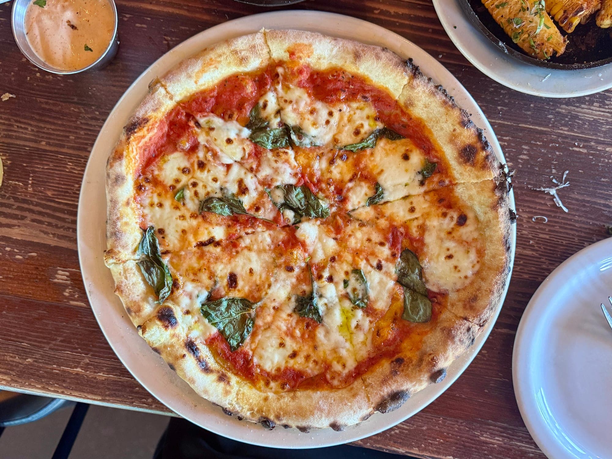 Une pizza margherita vue de dessus, avec des feuilles de basilic
