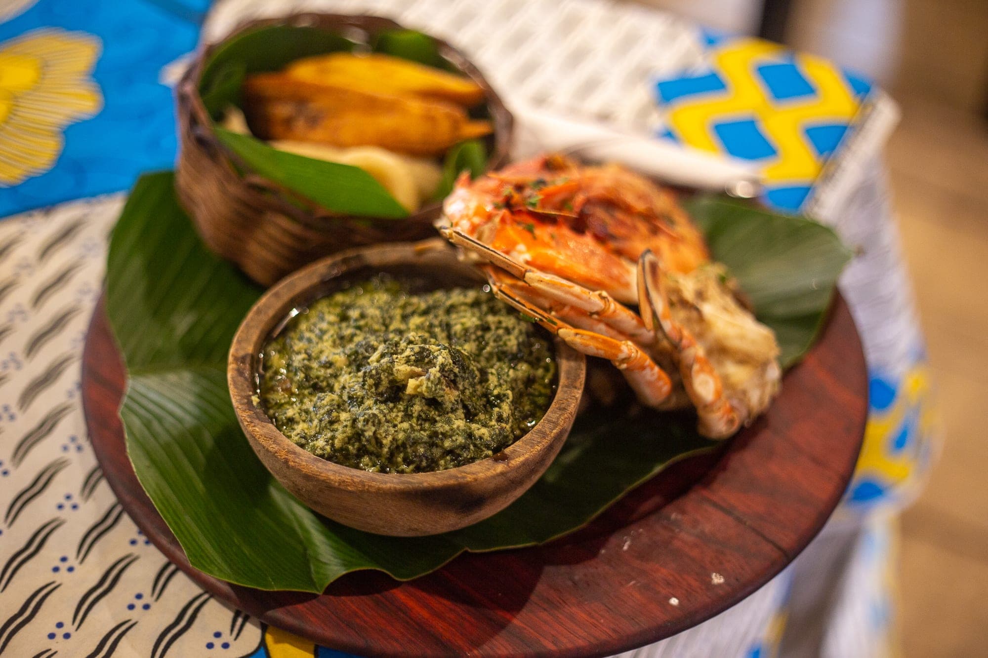 Un plat de ndolé servi avec du crabe et des crevettes sur une feuille de bananier